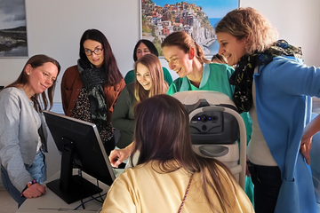 Personen stehen um Computer herum 