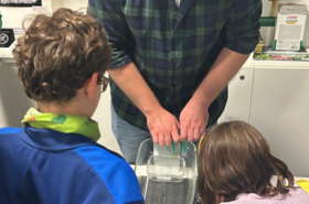 Mann beim Experiment vor Kindern